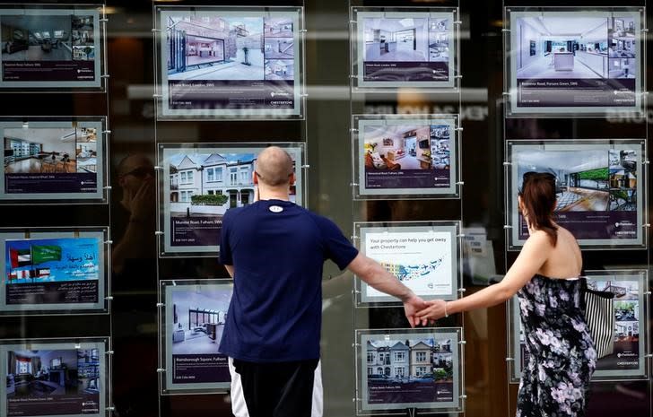 A couple view properties for sale in an estate agents window in London, Britain August 22, 2016. REUTERS/Peter Nicholls/File Photo