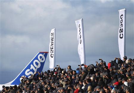 Bombardier employees and guests watch as the CSeries aircraft taxis past for its first test flight in Mirabel, Quebec, September 16, 2013. REUTERS/Christinne Muschi