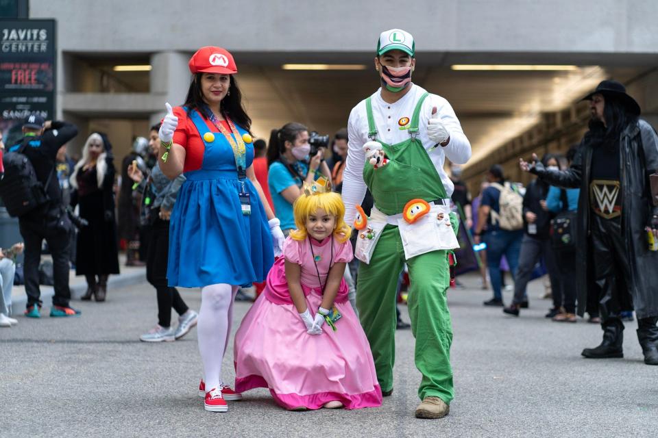 A family dressed as Super Mario characters Mario, Peach, and Luigi at New York Comic Con 2021.