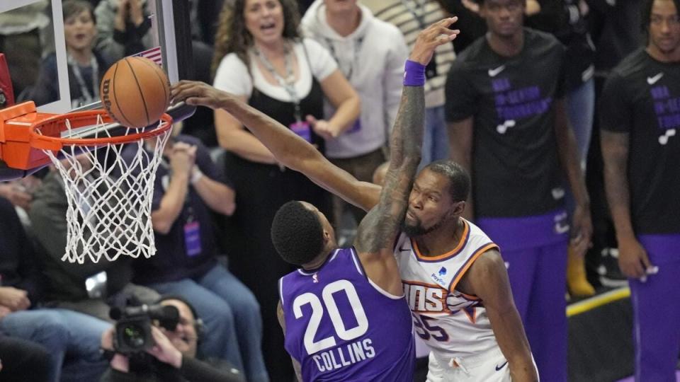 Utah Jazz forward John Collins (20) fouls Phoenix Suns forward Kevin Durant (35) during the second half of an NBA basketball in-season tournament game Friday, Nov. 17, 2023, in Salt Lake City. (AP Photo/Rick Bowmer)