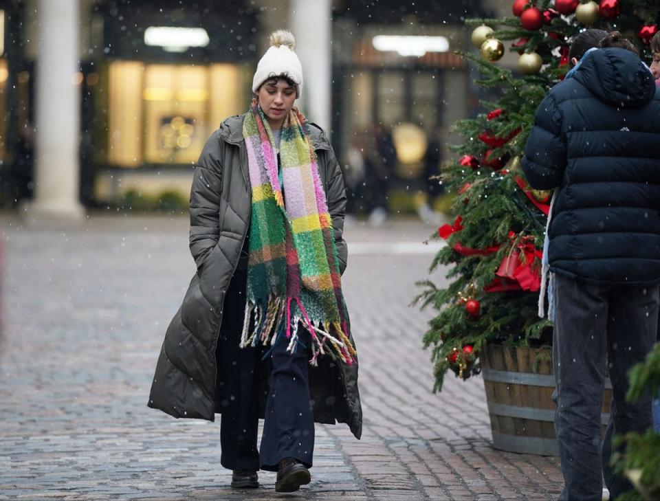 A woman walks through Covent Garden (PA)