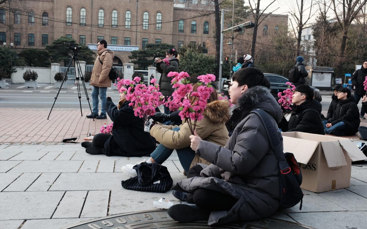 South Korean students gather with bouquets of rosebays to plan for Kim Jong-un's trip to Seoul - Junho Lee