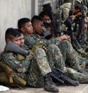 Government soldiers take a rest during a lull in their operation against Muslim rebels in downtown Zamboanga September 11, 2013. (REUTERS/Erik De Castro)