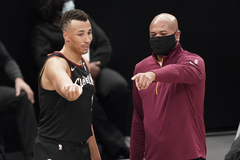 Cleveland Cavaliers head coach J.B. Bickerstaff, right, talks with Dante Exum in the second half of an NBA basketball game against the Philadelphia 76ers, Sunday, Dec. 27, 2020, in Cleveland. (AP Photo/Tony Dejak)