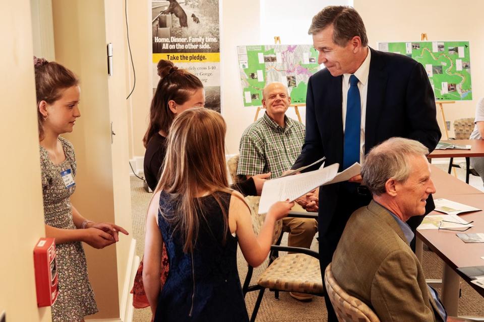 FernLeaf Charter school students Joy Mast, Elsa Rule and Cailee Montague present wildlife advocacy letters to North Carolina Gov. Roy Cooper at a June 2 meeting in Asheville.