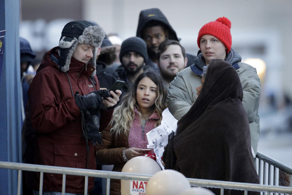 People wait in the cold outside a Best Buy store for it to open for a Black Friday sale Thursday, Nov. 28, 2019, in Overland Park, Kan. (AP Photo/Charlie Riedel)
