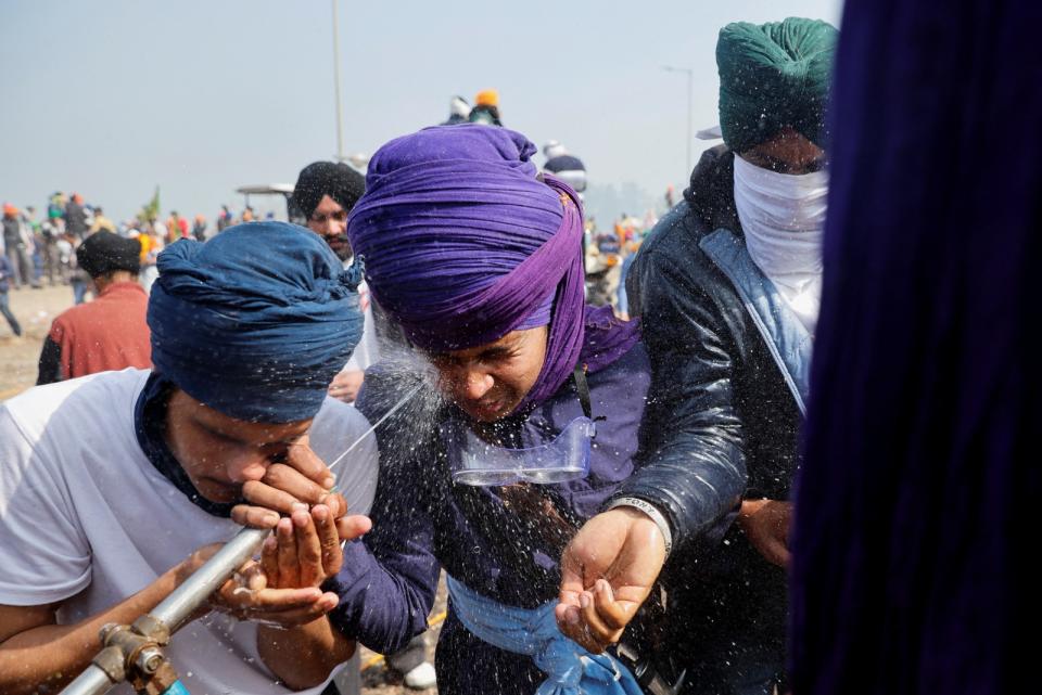 被催淚瓦斯噴到的印度示威農民，2月21日用清水沖眼睛。路透社