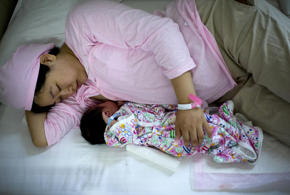 In this Wednesday, Aug. 7, 2013 photo, Chinese new mother Qi Wenjuan breastfeeds her 1-day-old son at Tiantan Hospital’s maternity ward in Beijing, China. China’s rates of breastfeeding are among the world’s lowest. But health workers and the government are trying to revive the tradition, and a drumbeat of safety scares over commercially produced milk is giving them new leverage. (AP Photo/Andy Wong)
