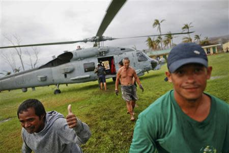 A survivor of Typhoon Haiyan gestures after receiving aid delivered by a U.S. military helicopter to a isolated village north of Tacloban November 17, 2013. REUTERS/Damir Sagolj