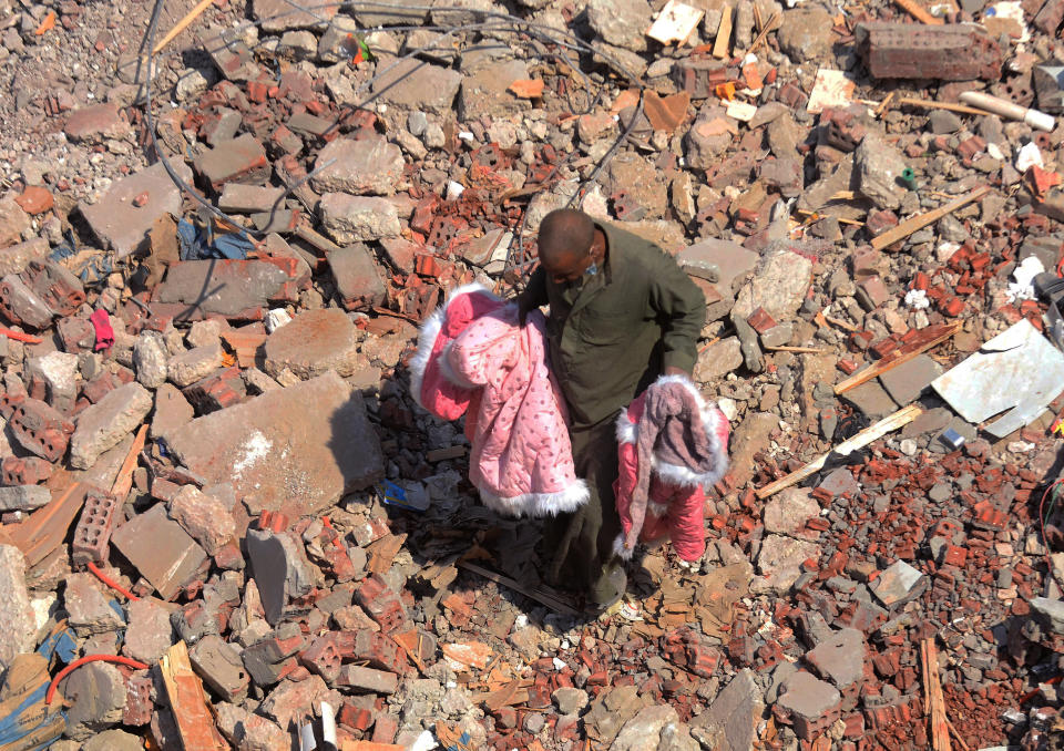 A man walks on the rubble of a collapsed apartment building in the el-Salam neighborhood, in Cairo, Egypt, Saturday, March 27, 2021. A nine-story apartment building collapsed in the Egyptian capital early Saturday, killing at several and injuring about two dozen others, an official said. (AP Photo/Tarek wajeh)