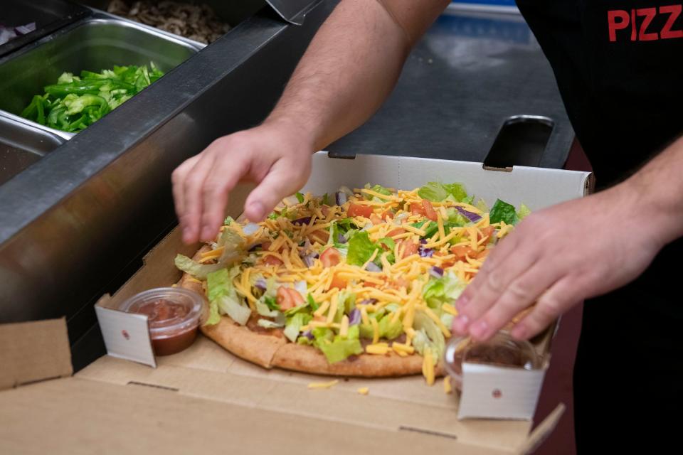 Hurricane Pizza co-owner Roy Allsworth puts the finishing touches on a Mexicali Hurricane pizza on Monday, Jan 10, 2022. 