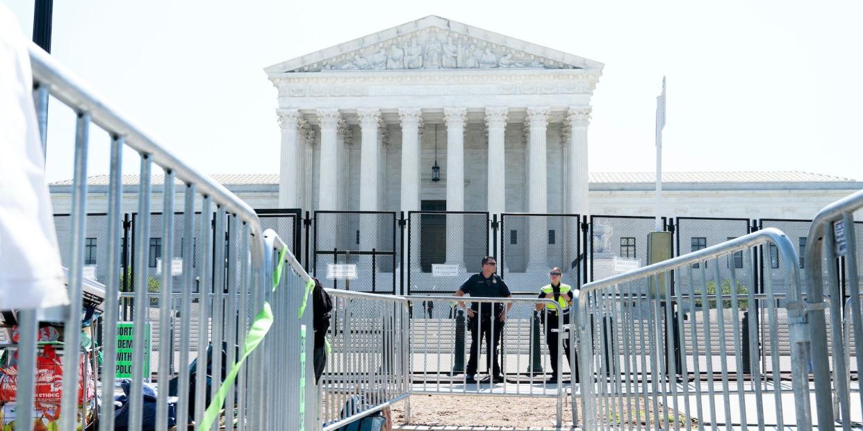 Security works by fencing outside the Supreme Court, Wednesday, June 15, 2022, in Washington