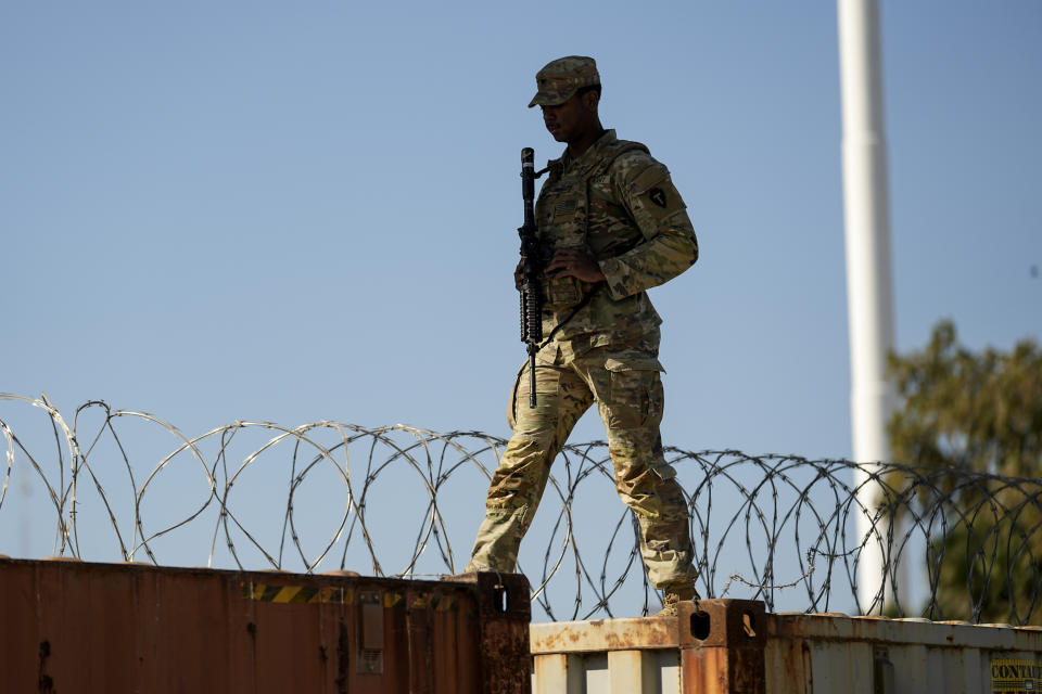 A guardsman walks over rail cars with Concertina wire along the Texas-Mexico border, Wednesday, Jan. 3, 2024, in Eagle Pass, Texas. U.S. House Speaker Mike Johnson is leading about 60 fellow Republicans in Congress on a visit to the Mexican border. Their trip comes as they are demanding hard-line immigration policies in exchange for backing President Joe Biden's emergency wartime funding request for Ukraine. (AP Photo/Eric Gay)