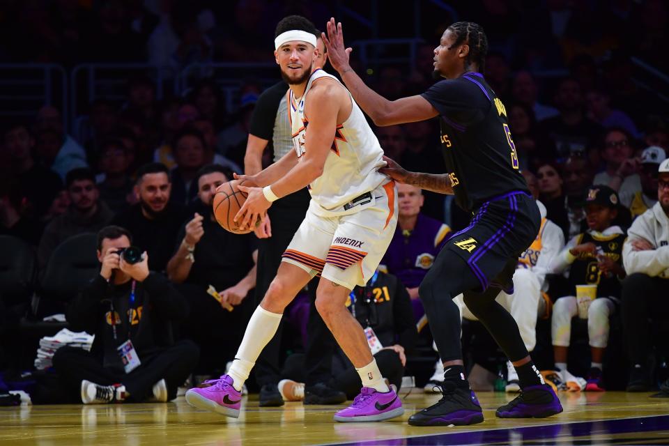 Phoenix Suns guard Devin Booker (1) moves the ball against Los Angeles Lakers forward Cam Reddish (5) during the first half of the In-Season Tournament quarterfinal at Crypto.com Arena in Los Angeles on Dec. 5, 2023.
