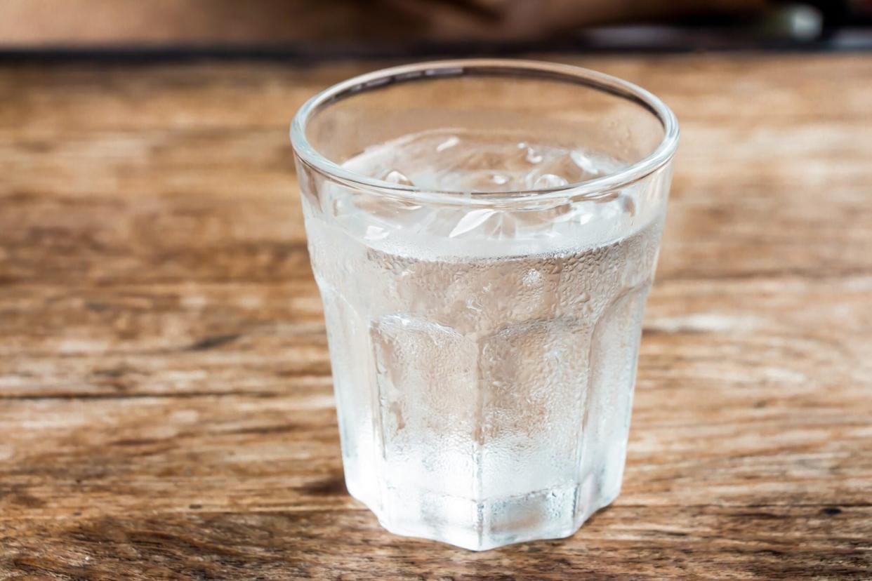 glass of water melting onto wood table