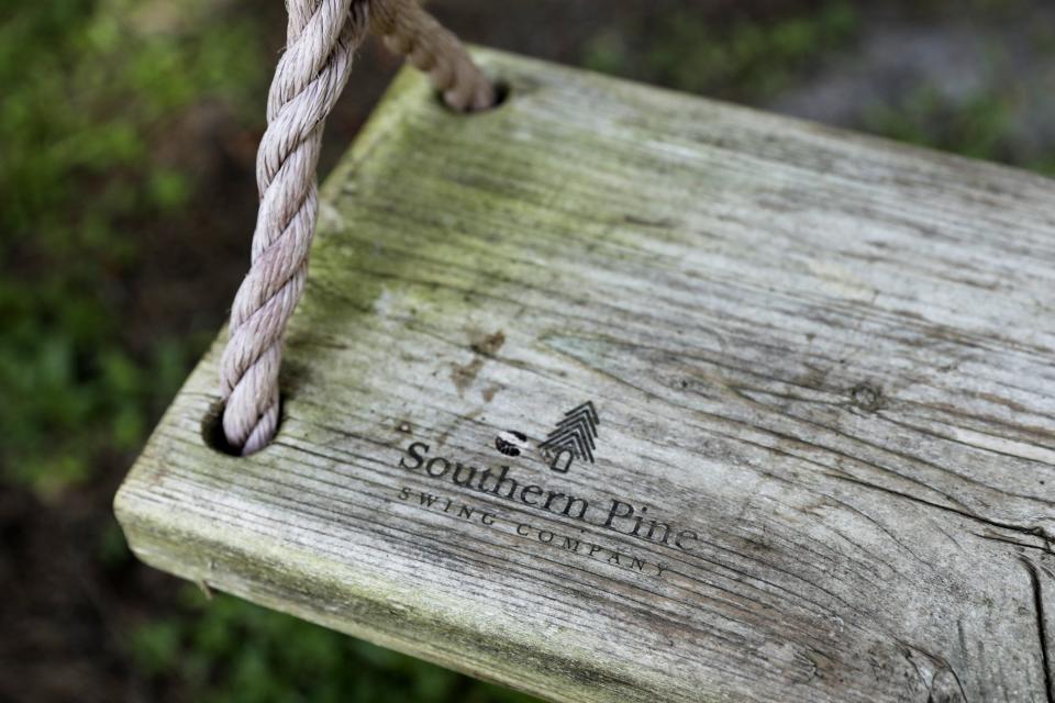 The branded logo of the Southern Pine Swing Co. is seen on one of the weathered and well-used swings in the front yard of the West family home just south of San Marco in Jacksonville.