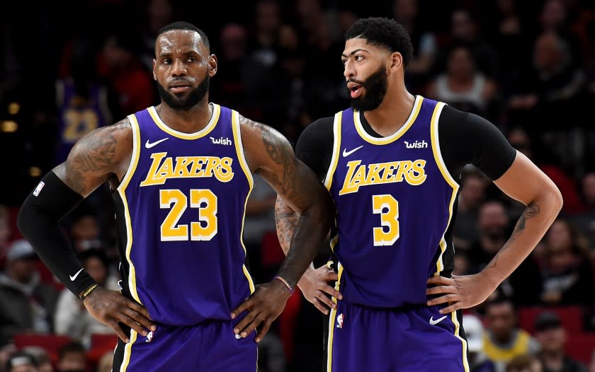 LeBron James #23 and Anthony Davis #3 of the Los Angeles Lakers speak during a time out.