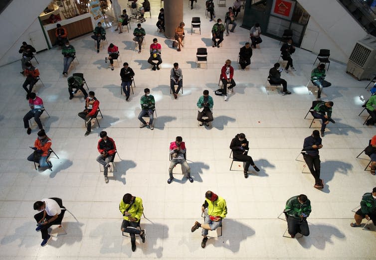 <span class="caption">Food delivery workers await the orders of customers in self-isolation. Bangkok, Thailand, March 24 2020.</span> <span class="attribution"><a class="link " href="https://webgate.epa.eu/webgate" rel="nofollow noopener" target="_blank" data-ylk="slk:EPA-EFE/RUNGROJ YONGRIT;elm:context_link;itc:0;sec:content-canvas">EPA-EFE/RUNGROJ YONGRIT</a></span>