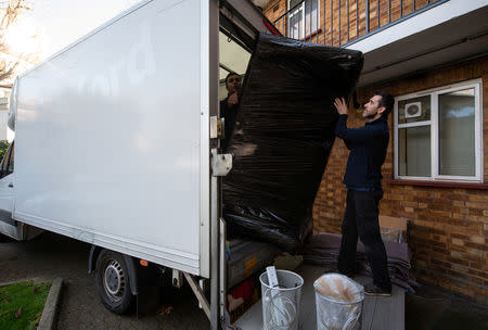 Adi (R), 37, works with his colleague Alexandru, who is also from Romania, for a removal company, in London, Britain, February 14, 2019. REUTERS/Alecsandra Dragoi