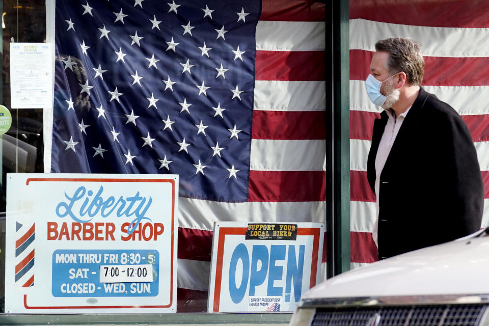 A customer wears a mask as he walks to a barber shop in Libertyville, Ill., Thursday, Dec. 3, 2020. Thousands of Illinois businesses received millions in loans under a federal government program created to help small companies recover from the economic crisis left in the wake of the pandemic. (AP Photo/Nam Y. Huh)