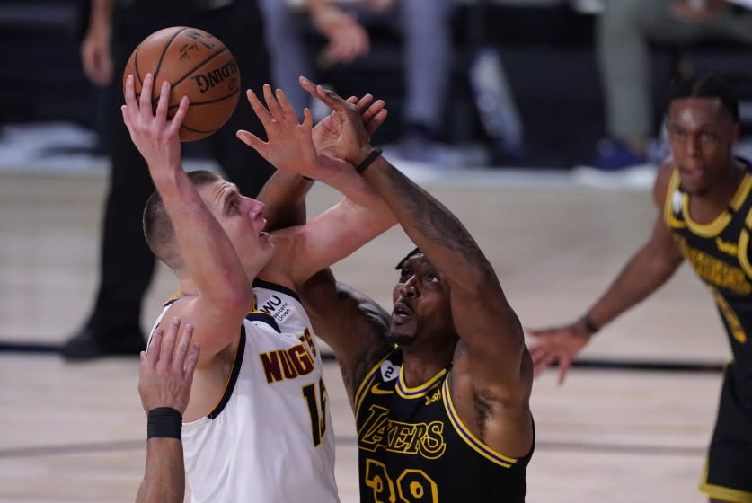 Denver Nuggets' Nikola Jokic (15) shoots over Los Angeles Lakers' Dwight Howard (39) during the first half.