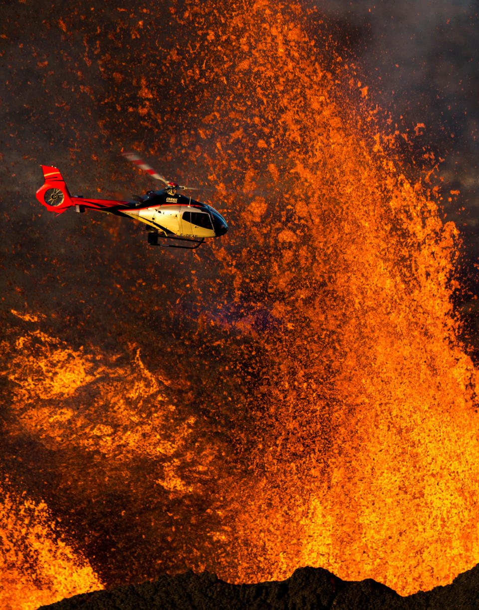 The magnificent moment when a daring helicopter pilot took a flight over an erupting volcano. (Photo: Lionel Ghighi/Caters News)