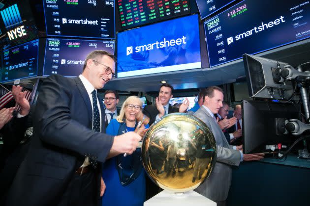 Smartsheet CEO Mark Mader, left, joined by CFO Jennifer Ceran and John Tuttle, Global Head of Listings at NYSE, rings The Opening Bell. (NYSE photo). <strong>Read stories <a href="https://www.geekwire.com/2018/2019-blockbuster-year-tech-ipos-uber-lyft-slack-airbnb-others-prep-go-public/" rel="nofollow noopener" target="_blank" data-ylk="slk:here;elm:context_link;itc:0;sec:content-canvas" class="link ">here</a> and <a href="https://www.geekwire.com/2018/smartsheet-raises-150m-ipo-setting-stock-price-15-share-expected-range/" rel="nofollow noopener" target="_blank" data-ylk="slk:here;elm:context_link;itc:0;sec:content-canvas" class="link ">here</a></strong>.