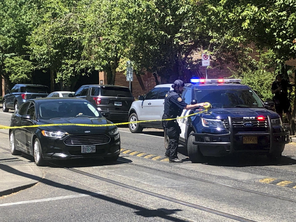 A police officer tapes off a crime scene on Saturday, July 22, 2023, after a shooting at Legacy Good Samaritan Medical Center in Portland, Ore. Gunfire erupted in a maternity unit of the Oregon hospital last weekend, fatally wounding an unarmed security guard and leading to renewed calls Monday, July 24, to protect health care workers from increasing violence. (Maxine Bernstein/The Oregonian via AP)