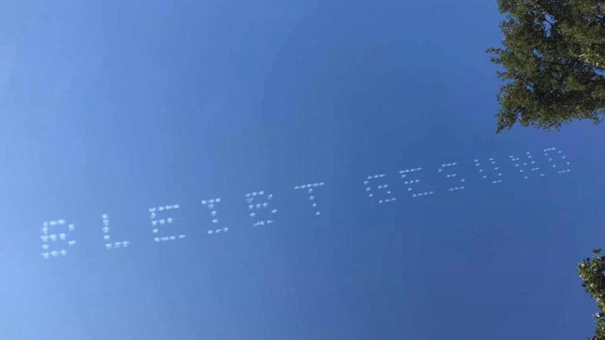 Der Schriftzug «Bleibt Gesund» am Himmel über München.