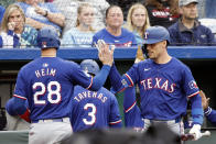 Texas Rangers' Jonah Heim (28) celebrates with Evan Carter, right, after scoring off a Nathaniel Lowe single during the fourth inning of a baseball game against the Kansas City Royals in Kansas City, Mo., Saturday, May 4, 2024. (AP Photo/Colin E. Braley)