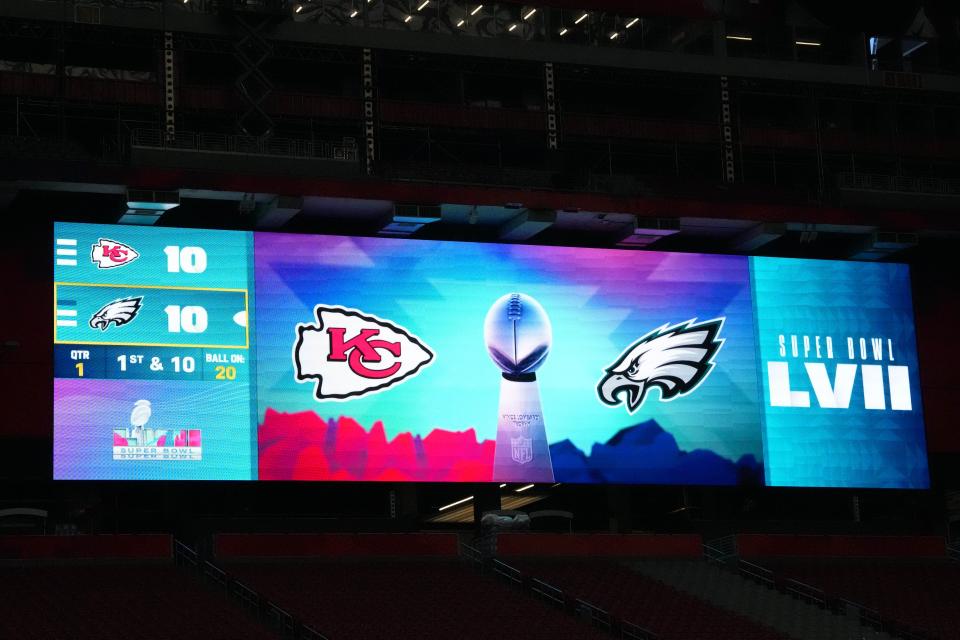 The logos of the Kansas City Chiefs and the Philadelphia Eagles with a Vince Lombardi Trophy on the video board prior to Super Bowl 57 at State Farm Stadium.