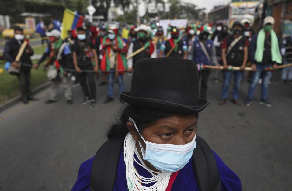 Members of the Indigenous Guard get ready to take part in an anti-government march in Bogota, where thousands traveled in a caravan from Cali, Colombia, Monday, Oct. 19, 2020. The leaders of the indigenous communities say they are mobilizing to reject massacres, assassinations of social leaders, criminalization of social protest, to defend their territory, democracy and peace, and plan to stay in the capital for a nationwide protest and strike on Oct. 21. (AP Photo/Fernando Vergara)