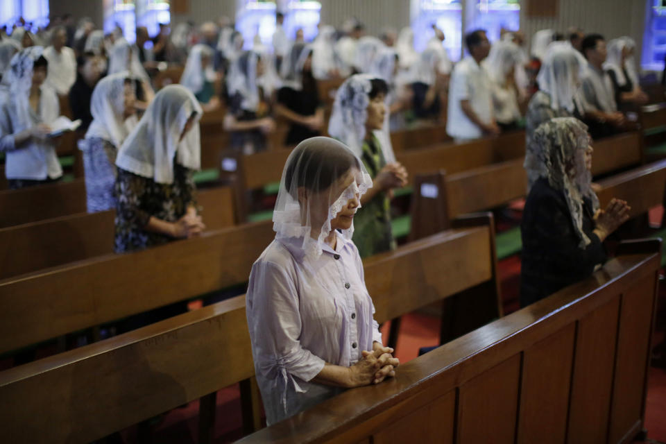 FILE - In this Aug. 9, 2015, file photo, Catholics offer prayers at an early morning Mass to pay respect to the victims of the atomic bombing at the Urakami Cathedral in Nagasaki, southern Japan. The Vatican said Friday, Sept. 13, 2019, Pope Francis will visit Thailand and Japan on Nov. 19-26. (AP Photo/Eugene Hoshiko, File)
