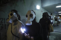 Protesters wear paper face masks and hold up their mobile phone lights in Hong Kong, Friday, Oct. 18, 2019. Hong Kong pro-democracy protesters are donning cartoon/superhero masks as they formed a human chain across the semiautonomous Chinese city, in defiance of a government ban on face coverings. (AP Photo/Kin Cheung)