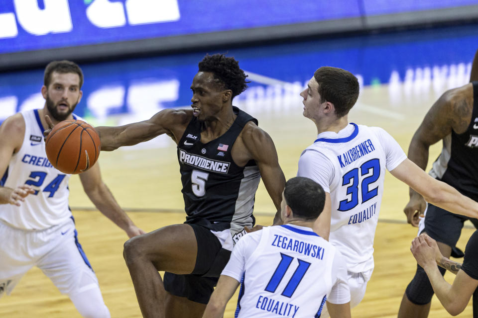 Creighton center Ryan Kalkbrenner (32) fouls Providence forward Jimmy Nichols Jr. (5) in the first half during an NCAA college basketball game on Wednesday, Jan. 20, 2021, in Omaha, Neb. (AP Photo/John Peterson)