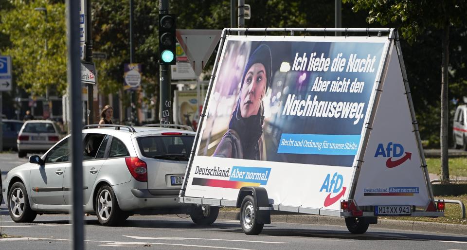 FILE - In this Wednesday, Aug. 25, 2021 file photo a car pulls an election poster for the right wing party 'Alternative for Germany' (AfD) at a street in Duesseldorf, Germany. Migration is a side issue in this year's German election campaign, but that hasn't stopped the country's biggest far-right party from trying to play it up. (AP Photo/Martin Meissner)