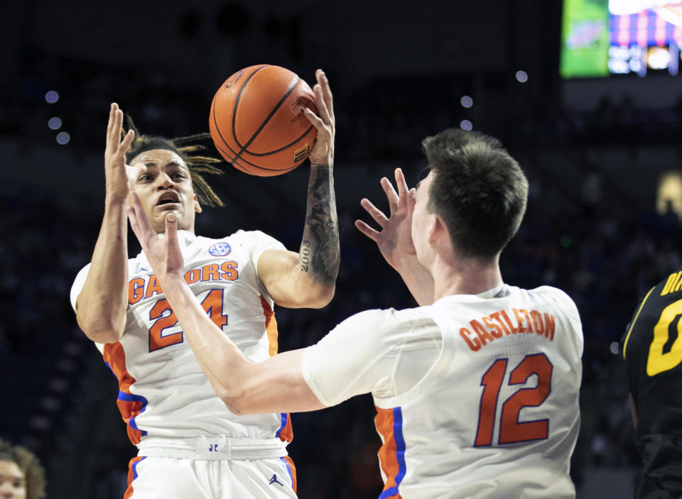 Florida guard Riley Kugel (24) and forward Colin Castleton (12) go for the rebound during the first half of an NCAA college basketball game against Missouri Saturday, Jan. 14, 2023, in Gainesville, Fla. (AP Photo/Alan Youngblood)