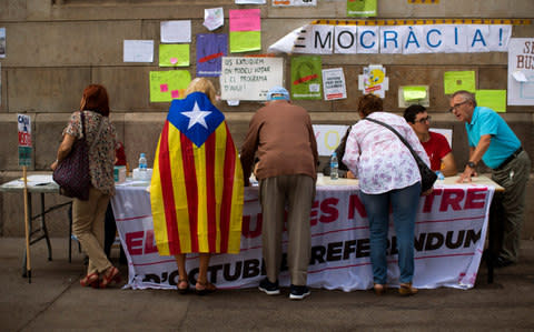 Catalan people receive information about where to vote for the referendum, - Credit: AP