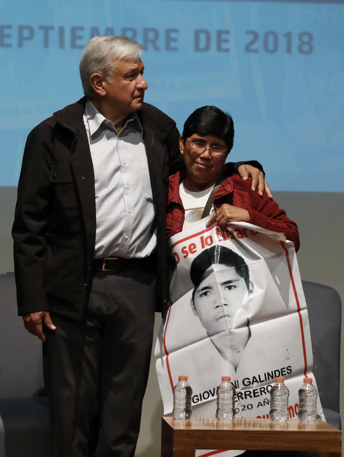 ADDS NAME OF WOMAN - President-elect Andres Manuel Lopez Obrador embraces Maria Elena Guerrero, mother of one of the 43 college students who disappeared on Sept. 26, 2014, at the Memory and Tolerance Museum in Mexico City, Wednesday, Sept. 26, 2018. Later in the day, family members and supporters, who do not accept the findings of government investigations, will march to mark four years since the students disappearance at the hands of police. (AP Photo/Rebecca Blackwell)