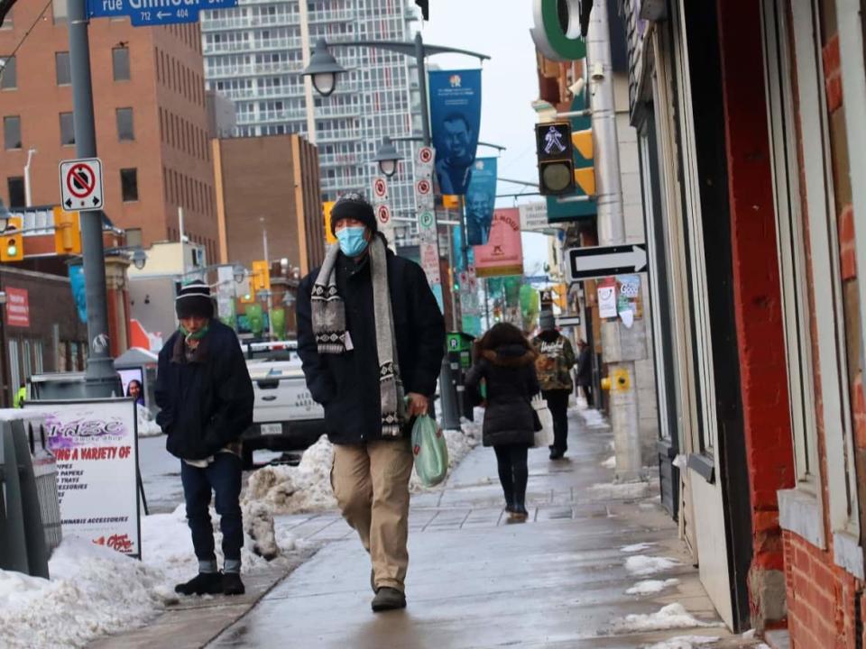 Pedestrians walk along Bank Street in downtown Ottawa in early December 2021 during the COVID-19 pandemic. On Sunday, health officials reported 333 new cases of the virus.  (Trevor Pritchard/CBC - image credit)