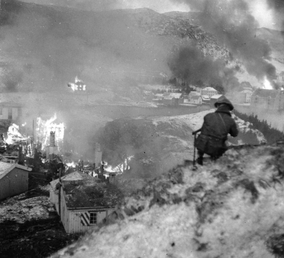 A member of a British-Norwegian commando group watches as the German garrison on Vaagsoy and Maaloy bursts into flames, after an air raid supporting a British offensive mission, code-named Operation Archery, December 27, 1941, in German-occupied Norway. - AP