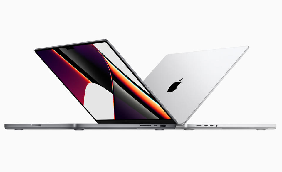 Two of Apple&#39;s 14-inch MacBook Pro half open on a white background.