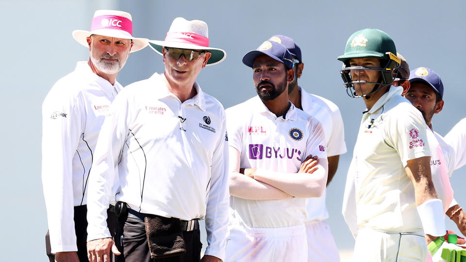 Umpires Paul Reiffel and Paul Wilson, Mohammed Siraj and Tim Paine look at the crowd during a suspension in play following a complaint regarding spectators during day four of the Third Test match between Australia and India at the SCG. (Photo by Cameron Spencer/Getty Images)