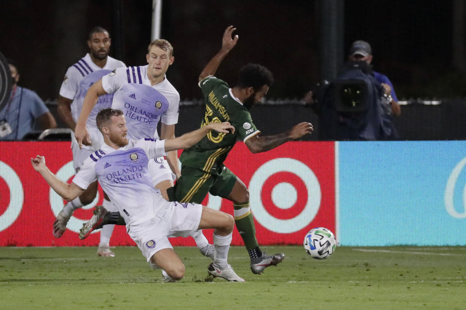 Portland Timbers midfielder Eryk Williamson (30) runs with the ball away from Orlando City midfielder Oriol Rosell (20) and forward Chris Mueller (9), during the first half of an MLS soccer match, Tuesday, Aug. 11, 2020, in Kissimmee, Fla. (AP Photo/John Raoux)