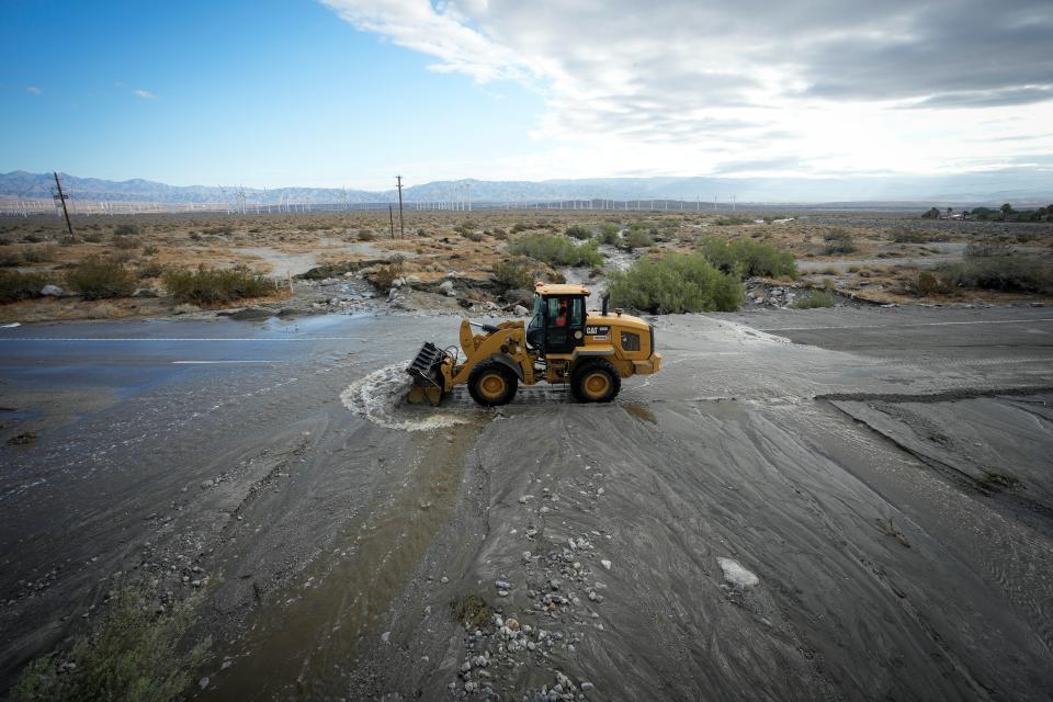 A road crew works to clear debris from California State Highway 111, a major road leading in and out of Palm Springs, covered with moving water the morning after Tropical Storm Hilary passed Palm Springs, California, U.S., August 21, 2023 (REUTERS)