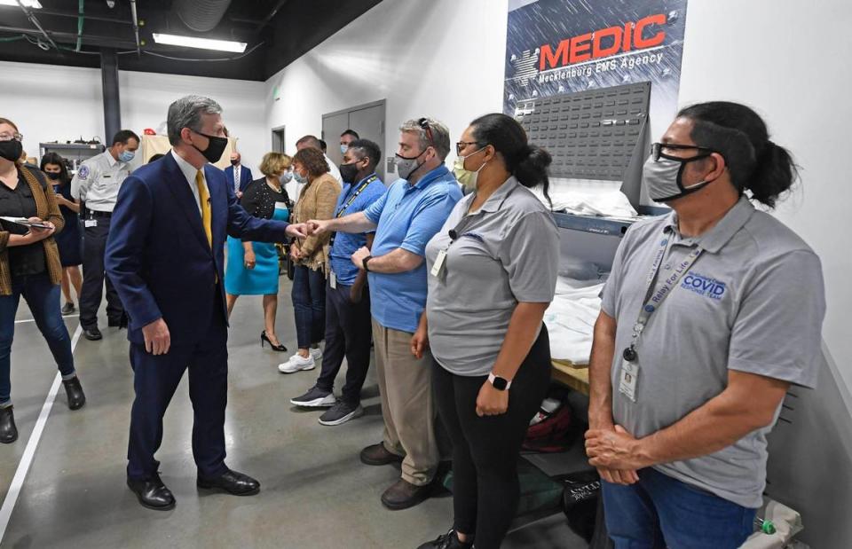 N.C. Gov. Roy Cooper greets workers who administer at-home COVID vaccines during a tour of the Mecklenburg County Vaccine Site at MEDIC Clinic on Wednesday, May 5, 2021.