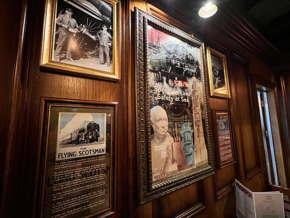 Several framed posters of Flying Scotsman information and historical pictures inside a Wetherspoon at Edinburgh Airport