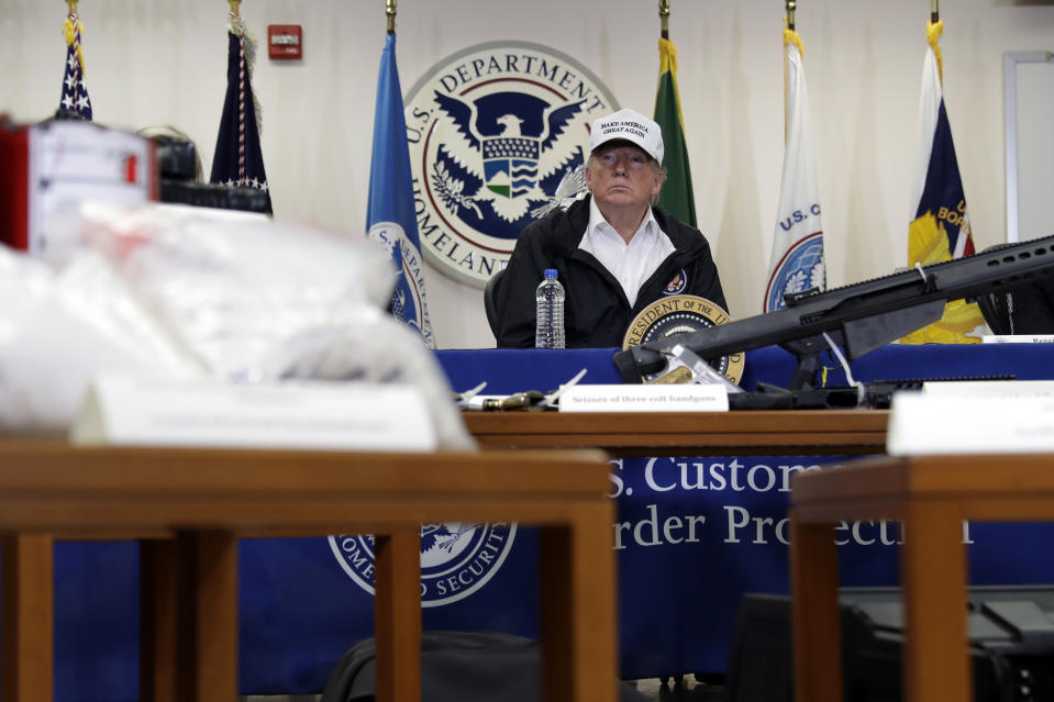 FILE - In this Jan. 10, 2019, file photo, illegal drugs and weapons are displayed in the foreground as President Donald Trump speaks at a roundtable on immigration and border security at the U.S. Border Patrol McAllen Station in McAllen, Texas. In his demands that Congress set aside $5.7 billion for a border wall, President Donald Trump insists a physical barrier would stop heroin entering the U.S. from Mexico. But U.S. statistics, analysts and testimony at the trial of drug kingpin Joaquin "El Chapo" Guzman in New York show that most hard drugs entering the U.S. from Mexico come through land ports of entry staffed by agents, not open sections of the border. (AP Photo/Evan Vucci, File)