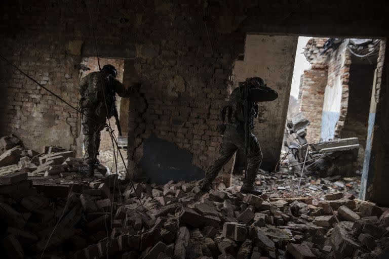 Soldados ucranianos de la 79ª Brigada de Asalto Aéreo avanzando por un edificio dañado en una zona de Marinka, en el este de Ucrania, el 26 de febrero de 2023. 