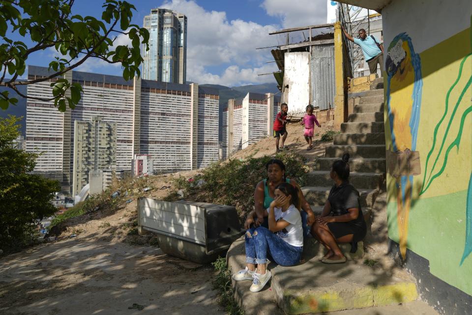 Residents gather outside their home in the San Agustin neighborhood of Caracas, Venezuela, Thursday, March 2, 2023. About three-quarters of Venezuelans live on less than $1.90 a day — the international benchmark of extreme poverty. (AP Photo/Ariana Cubillos)